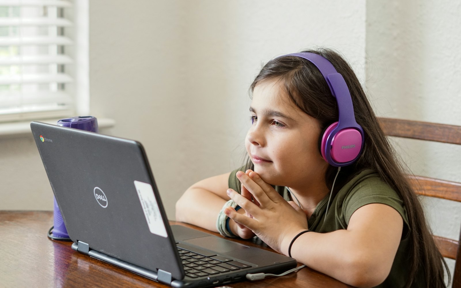A student with headphones taking a lesson on a laptop