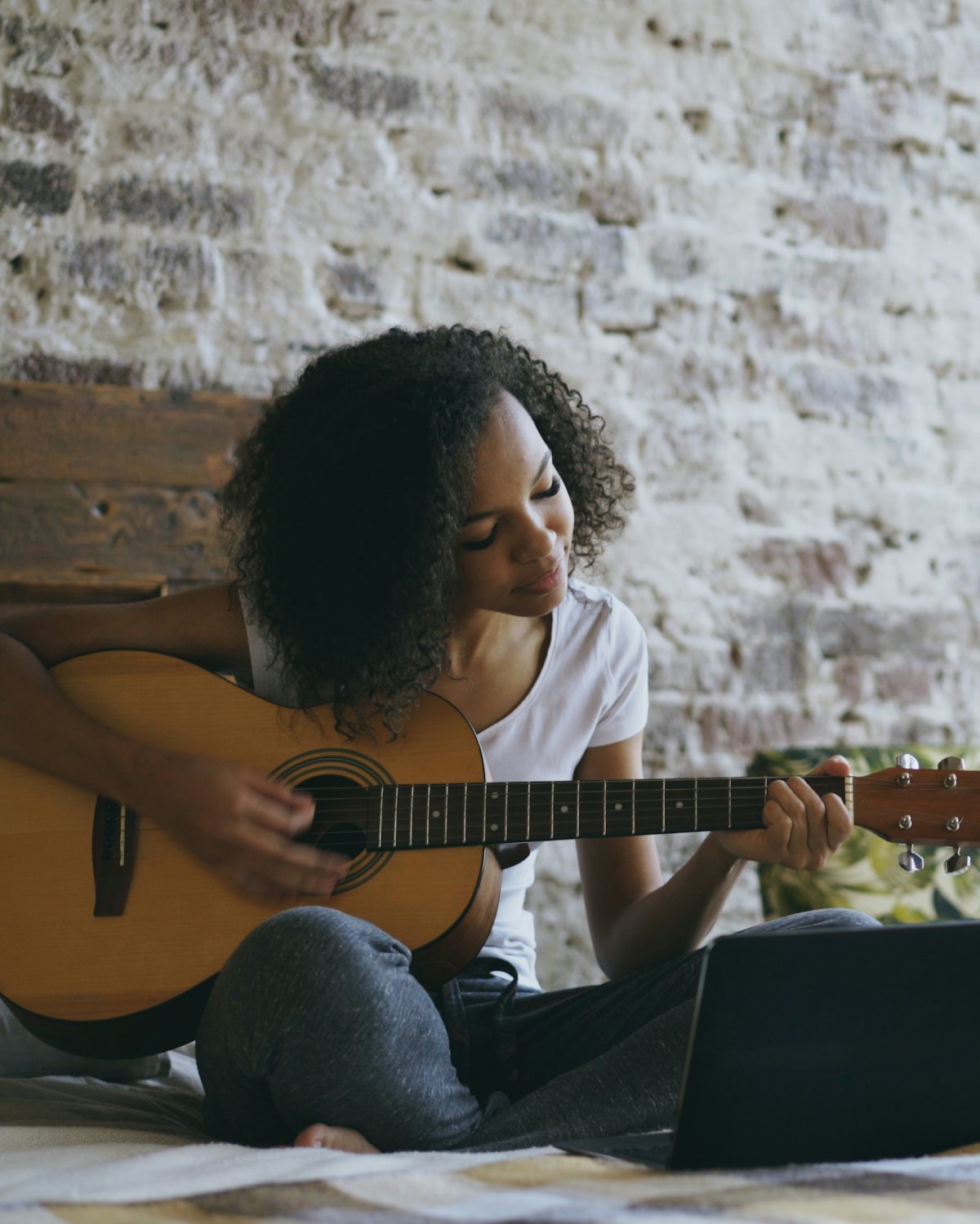 A musician practising along with a recording on a laptop